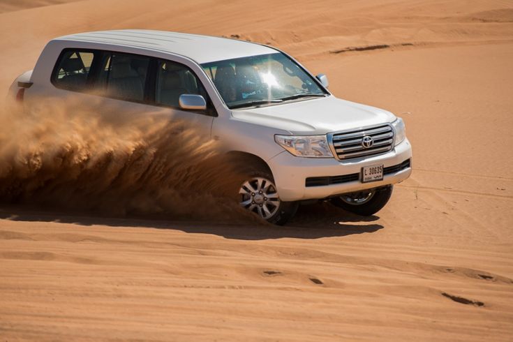 Adam City Tours Toyota Land Cruiser drifting over Sahara dunes